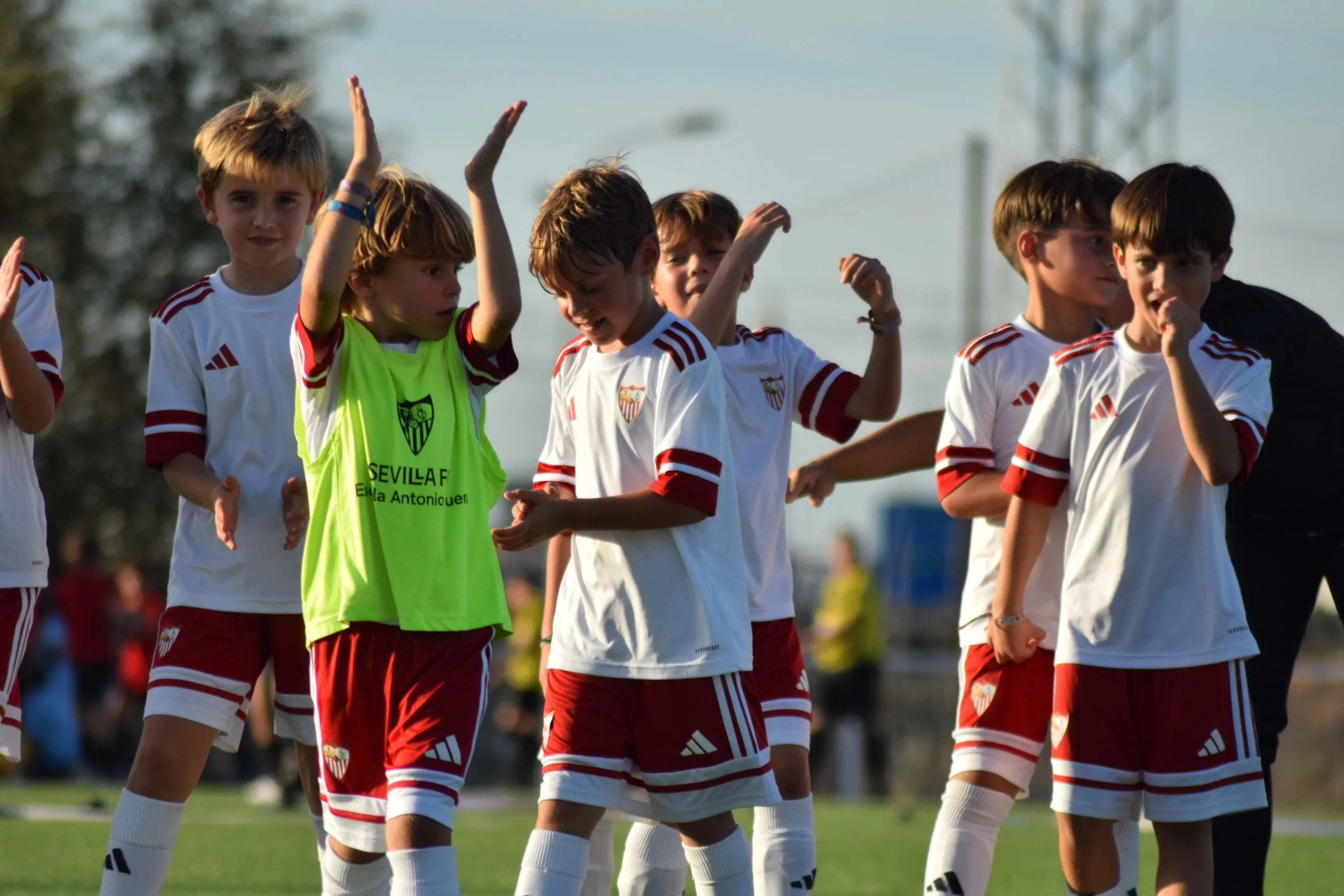 Giocatori della Sevilla FC Academy applaudono e festeggiano sul campo di allenamento
